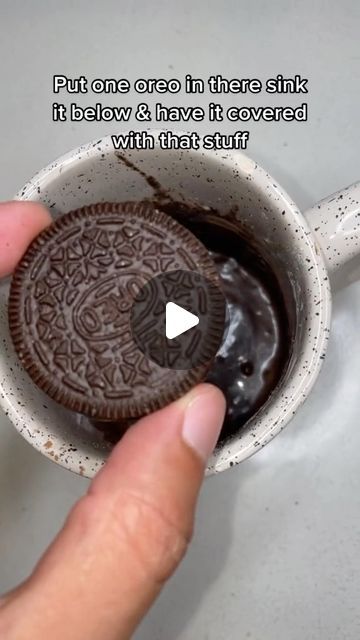 someone is holding an oreo cookie in a cup with the words, put one oreo in there sink if below & have it covered with that stuff