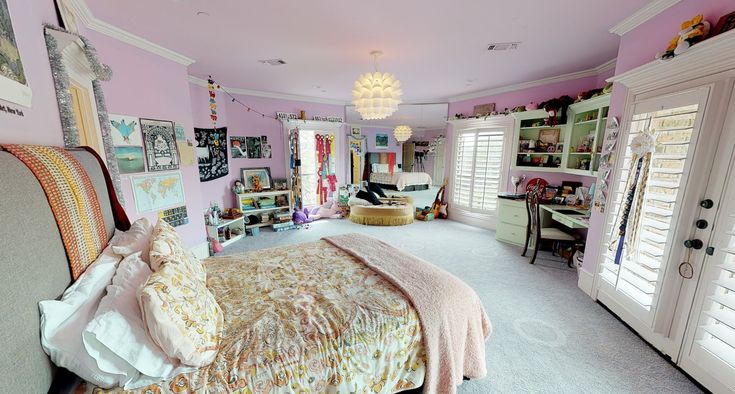 a bedroom with pink walls and lots of pictures on the wall