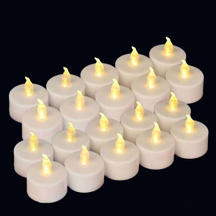 several rows of white candles with yellow lights on them