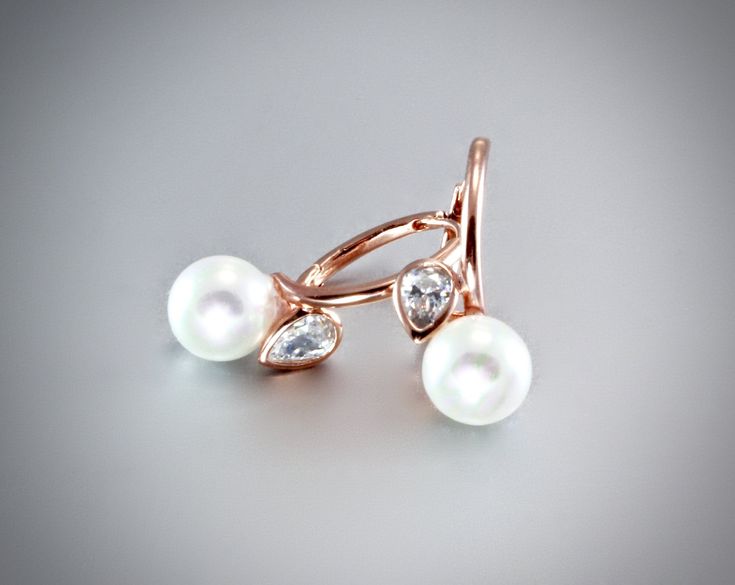 A delicate earring design created with lustrous white cultured pearls and a pear-cut cubic zirconia set in a 14K rose gold plated or rhodium plated component. Lever-back ear wires. Overall length of the earring is 24mm (approx. 1). Choose between Rose Gold and Rhodium finishes by selecting from the drop-down menu. Handcrafted. Rose gold has truly become the season's must-have in jewelry trends. All it takes is a simple glance at this gorgeous metal to see its extremely subtle and classy look tha Rose Gold Earrings With Pearl Charm For Anniversary, Fine Jewelry Rose Gold Pearl Drop Earrings, Rose Gold Pearl Charm Earrings For Anniversary, Rose Gold Pearl Drop Earrings Fine Jewelry, Rose Gold Cubic Zirconia Pearl Earrings For Anniversary, Formal Rose Gold Pear-shaped Pearl Earrings, Rose Gold Teardrop Pearl Earrings For Anniversary, Pear-shaped Rose Gold Cubic Zirconia Jewelry, Delicate Rose Gold Pear-shaped Jewelry