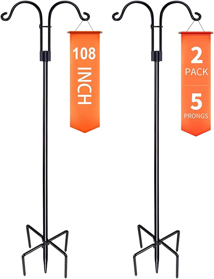 three orange banners hanging from black metal poles with two iron stands and one sign holder