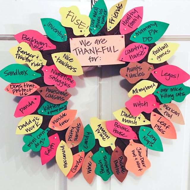 a wreath made out of colored paper with words written on the front and back sides