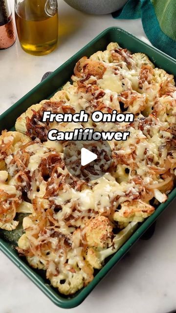 french onion cauliflower is in a green casserole dish