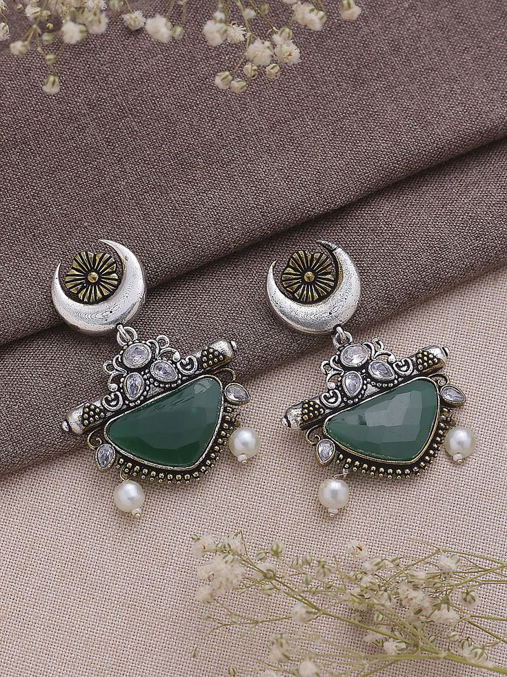 Dive into the realm of sophistication and charm with our Dual Tone Green Chandbali Earrings, a harmonious blend of tradition and contemporary flair. These earrings boast a graceful design adorned with exquisite half-moon detailing, showcasing the artisanal finesse that makes them a true embodiment of elegance. The dual tone green color palette imparts a refreshing and playful vibe, making them a versatile accessory that effortlessly transitions from day to night, from casual gatherings to festive celebrations. Meticulously crafted with precision, these earrings not only serve as a visual delight but also symbolize a timeless statement piece. Elevate your style effortlessly as you embrace the fusion of classic and modern aesthetics, allowing these Dual Tone Green Chandbali Earrings to becom Luxury Green Chandbali Jhumkas, Metal Chandbali Bridal Earrings, Dual-tone Chandbali Jewelry For Festive Season, Festive Brass Chandbalis With Matching Earrings, Festive Dual-tone Chandbali Jewelry, Fusion Style Chandbali Brass Jhumkas, Kundan Chandbali Fusion Danglers, Festive Bohemian Dual-tone Earrings, Elegant Silver Earrings For Eid