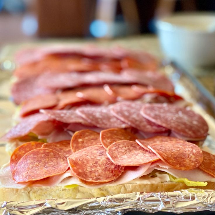 some slices of bread with pepperoni and other toppings on them sitting on a table