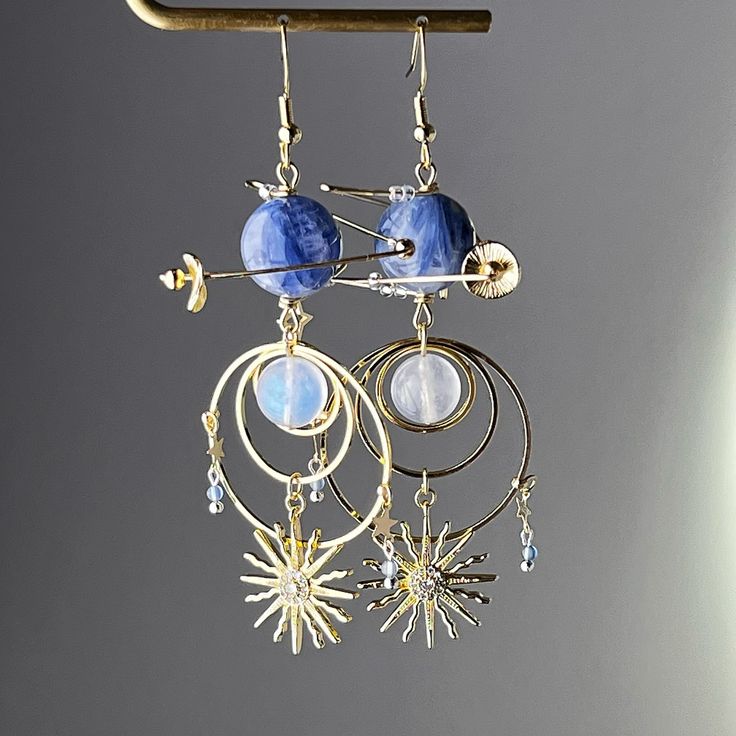 Blue Kyanite Neptune Planet Sun and Moonstone Earrings Experience the wonder of the universe with these Blue Kyanite Neptune Planet Sun and Moonstone Earrings! The intricate blue planet design combined with high quality Kyanite and blue moonstone make the perfect astrology themed accessory. Give the gift of cosmic beauty and inspire the senses with these unique earrings. As a gift shop, we offer a complimentary gift box for every order. Detail: Length of one earring - 90mm;  Size of beads - 13-1 Blue Round Earrings With Moon Charm, Celestial Blue Moonstone Jewelry, Blue Celestial Moonstone Jewelry, Celestial Blue Moon-shaped Earrings, Blue Moon Shaped Celestial Earrings, Blue Celestial Dangle Earrings, Blue Celestial Moon Earrings, Blue Celestial Round Earrings, Blue Moonstone Jewelry With Matching Earrings