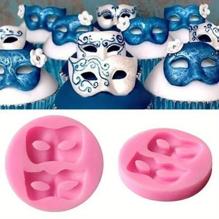 two cupcakes with blue and pink icing next to some masks on them