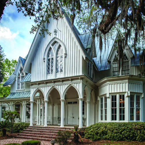 a large white house surrounded by trees and bushes