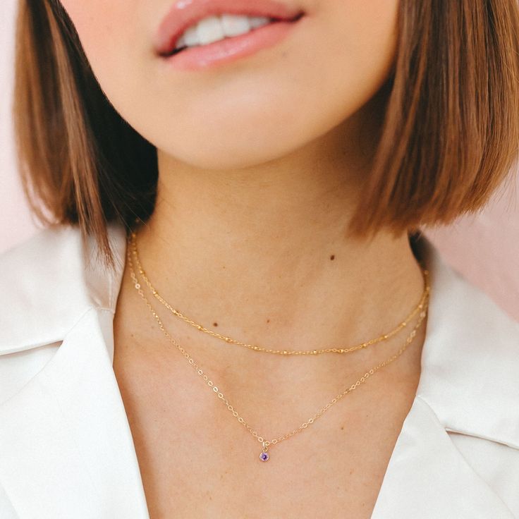 "Our dainty 14kt gold filled birthstone necklace features a tiny cubic zirconia in your choice of colored stone. These dainty birthstone necklaces are the perfect gift for a friend, sister, new mom or just for you! All items come gift boxed in our signature packaging. Ready to gift or treat yourself to a fun un-boxing moment. ♡ DETAILS: - 14kt gold filled chain and charm - won't tarnish or turn, water-proof - choose length at checkout - model wearing this 17\" layered with our satellite choker: https://etsy.me/3BxbYdA January Birthstone: Garnet February Birthstone: Amethyst March Birthstone: Aquamarine April Birthstone: Diamond May Birthstone: Emerald June Birthstone: Alexandrite July Birthstone: Ruby August Birthstone: Peridot September Birthstone: Sapphire October Birthstone: Tourmaline Birthstone Necklaces, Gold Birthstone Necklace, Personalized Gold Jewelry, Birthstone Charm Necklace, Deer Jewelry, February Birthstone Necklace, Horseshoe Necklace, Mini Gold, Pearl Necklace Earrings