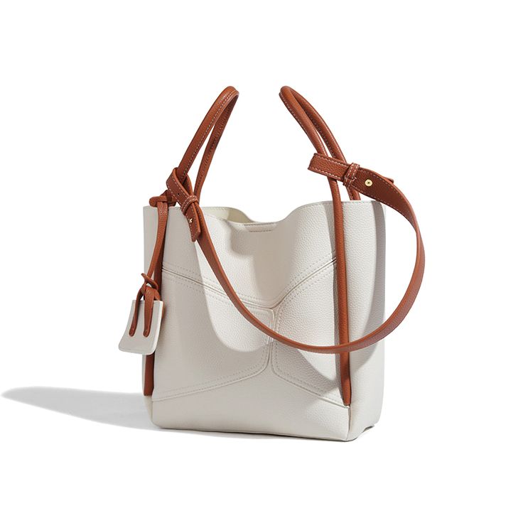 New to the bucket bag trend? You can't go wrong with our stylish drawstring bucket bag. Easy to wear and an instant wardrobe staple, this attractive piece comes in a cream-white and brown colour combination that can work well with a variety of outfits. For a dazzling look, we recommend styling it with a wrap dress and textured stiletto pumps.Weight: 620 gWidth (cm): 11 cmHeight (cm): 26 Color: WhiteStrap Length: 44 cmInterior Material: PolyesterMaterial_bag: PU LeatherBagType: Handbag & Crossbod Brown Colour Combination, Bucket Tote, Pu Leather Bag, Drawstring Bucket Bag, Bags Vintage, Luxury Designer Handbags, Handbags And Purses, Brown Colour, Bag Trends