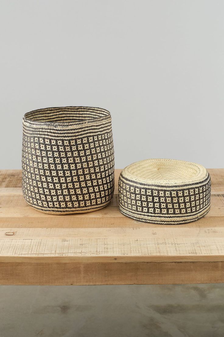 two woven baskets sitting on top of a wooden table next to each other and one is empty