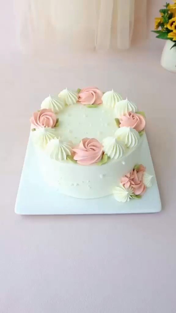 a white cake with pink frosting and flowers on it