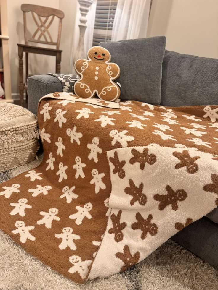 a brown and white teddy bear blanket sitting on top of a couch