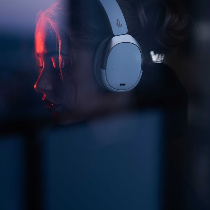 a woman wearing headphones looking out the window