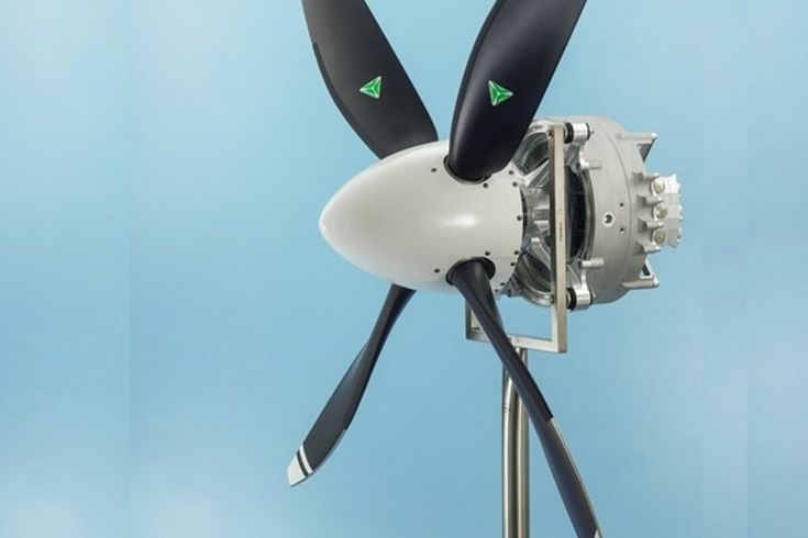 a white and black propeller with green arrows on it's blades in front of a blue background