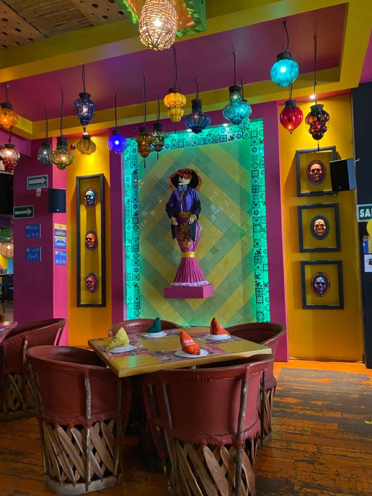 a brightly lit restaurant with colorful lighting and decorations on the walls, tables and chairs