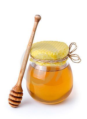 a jar of honey and a wooden stick