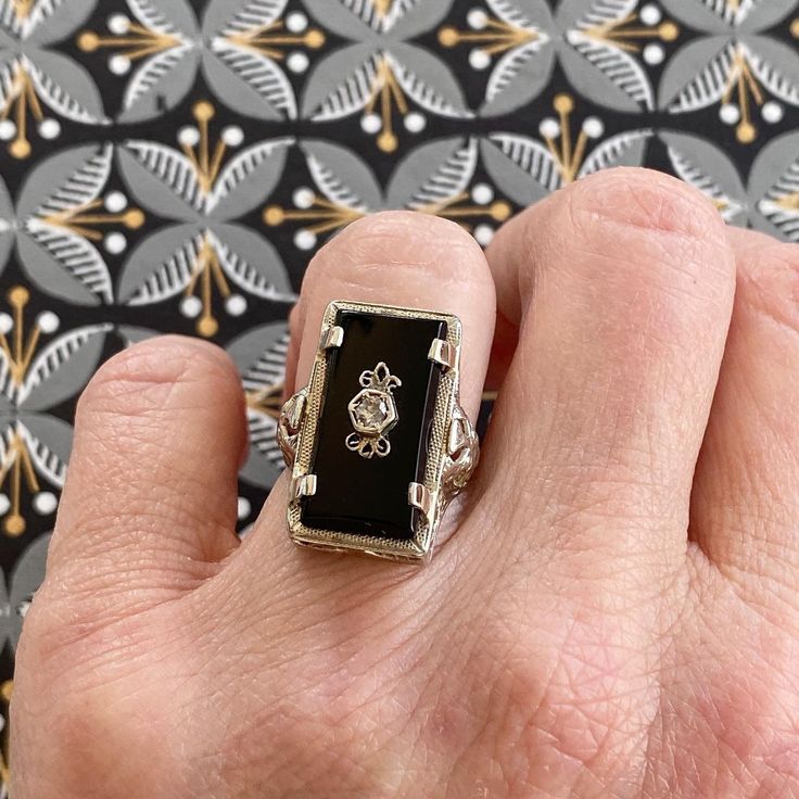 Details: Beautiful vintage onyx set in 14K white gold filigree. The filigree has a lovely art nouveau feel. The onyx is a very rich, deep black, and a rose cut Diamond is set in the center of the onyx stone. Hallmarks on the interior band read P&KCC and 14K. This is a stunning ring--you will not be disappointed! Please ask all necessary questions prior to placing an order. Measurements: The size is 6 US and can be sized for a fee. The stone measures 20mm x 10mm. Ring weighs 4.5 grams. Condit Black Oval Filigree Jewelry, Oval Black Filigree Jewelry, Luxury Black Filigree Jewelry, Black Oval Filigree Ring For Formal Occasions, Black Filigree Ring Jewelry, Black Filigree Ring, Black Jewelry With Intricate Design For Anniversary, Black Filigree Jewelry For Formal Occasions, Black Intricate Jewelry For Anniversary