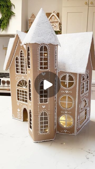 a gingerbread house made out of cardboard sitting on a kitchen counter