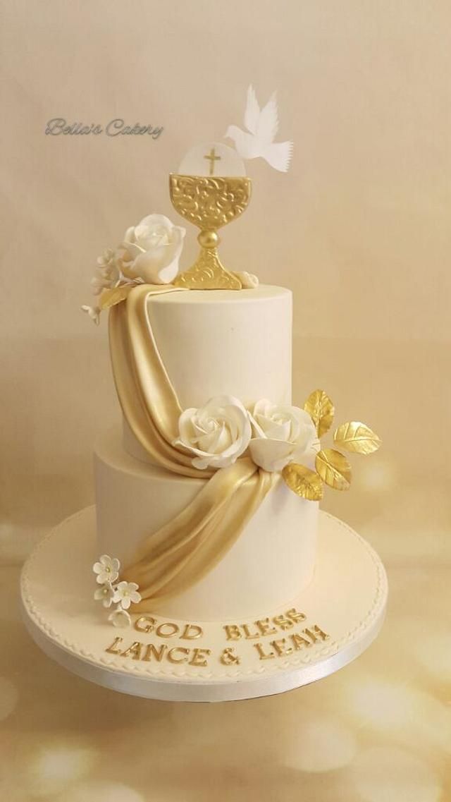 a white and gold wedding cake with flowers on top