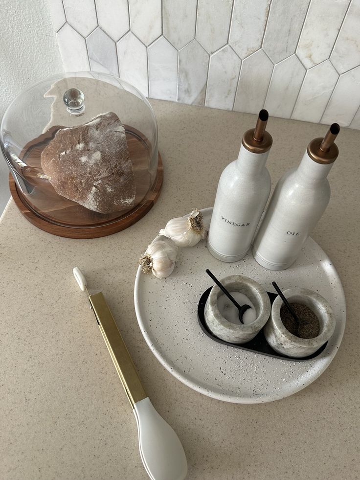 an assortment of items displayed on counter top with utensils and glass dome in background