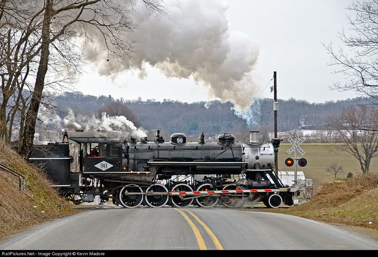 an old fashioned steam engine traveling down the road