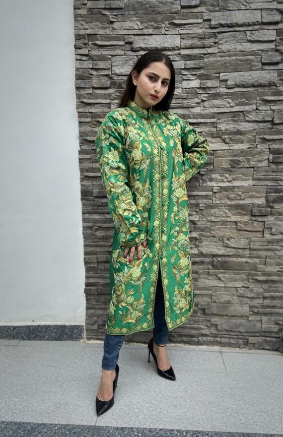 Get a polish look with this jacket. Pair it up with a skirt, trousers, dress or even a flowing maxi and be ready in style.Product Details- Condition: Brand New (made to order)- Handmade- Style: Coat- Fabric: Art Raw Silk/Pure Raw Silk/Wool- Embroidery: Kashmiri Aari Embroidery- Base Color: Green- Embroidery Color: Multi-Color- Fully Lined from Inside- Features Pockets on both sides- Length: 42" (107 cms approx)- Care Instructions: Dry Clean Only**If you want the coat to be shorter or longer, sen Long Green Jacket, Skirt Trousers, Coat For Woman, Boho Shawl, Green Embroidery, Embroidered Coat, Wool Embroidery, Aari Embroidery, Women Coat