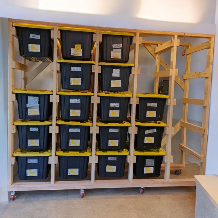 the shelves are filled with plastic bins and yellow labels on them, along with other storage containers