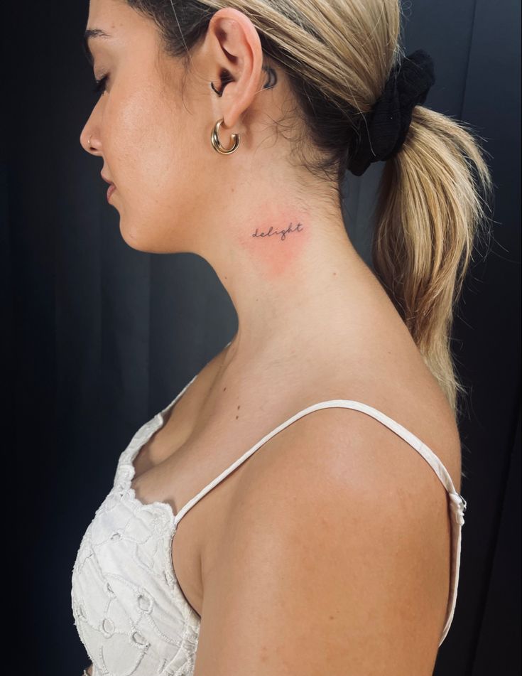 a woman with a small tattoo on her neck