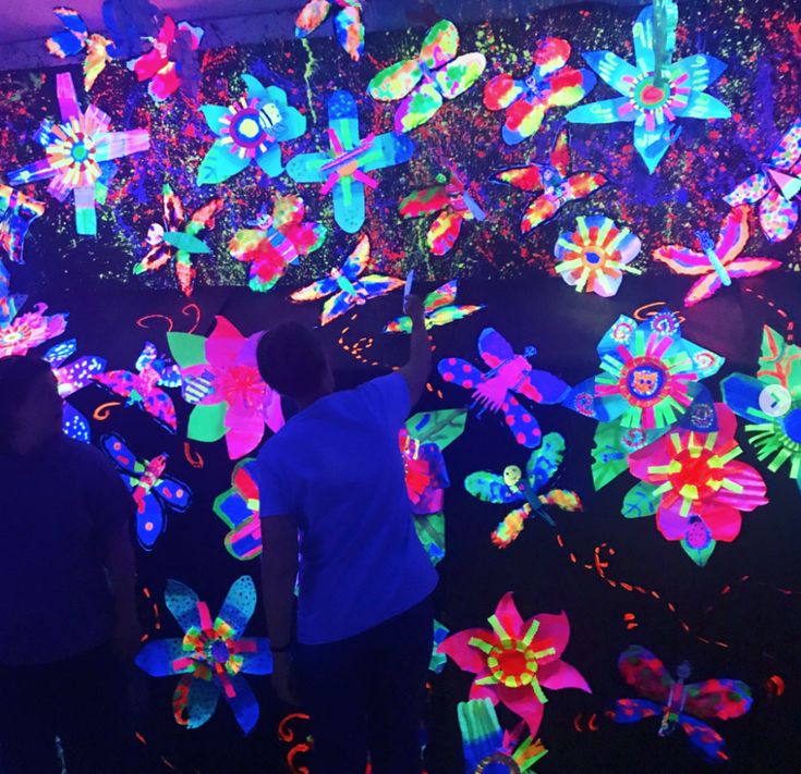 two people standing in front of an array of glowing butterflies