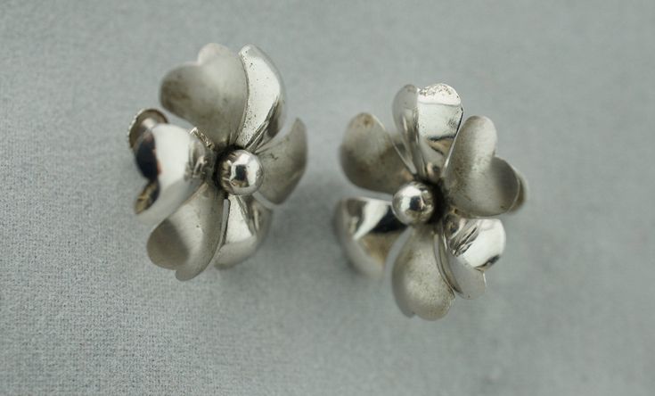 This is the perfect option for those who like cool, unique jewelry and the luxury, shine of sterling. This earrings are well made, cute and/or elegant in design, and very desirable. The earrings have the shape of flowers. The earrings have color of sterling. They're in good vintage condition. The clasps are in very good working condition. ♥ Age/era: Circa 1980s - 1999s. ♥ There are a hallmark. Sterling . ♥ The earrings are about 7/8'' in diameter. Every one interested in the jewelry should remem Formal Silver Flower-shaped Clip-on Earrings, Handmade Silver Flower Clip-on Earrings, Silver Flower Clip-on Earrings In Sterling Silver, Silver Sterling Silver Flower Clip-on Earrings, Silver Flower-shaped Clip-on Earrings For Anniversary, Classic Silver Flower Earrings, Silver Flower Clip-on Earrings, Elegant Sterling Silver Flower Clip-on Earrings, Silver Flower Shaped Earrings For Anniversary