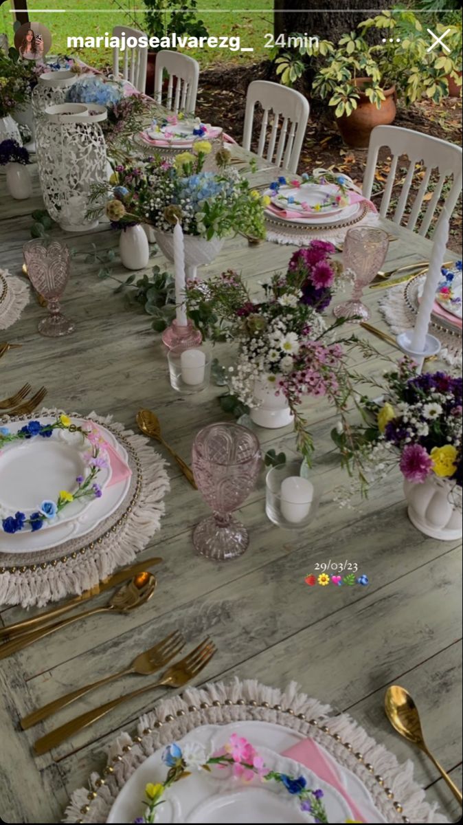 the table is set with flowers and plates