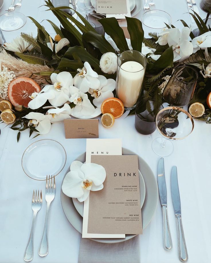 the table is set with silverware and flowers