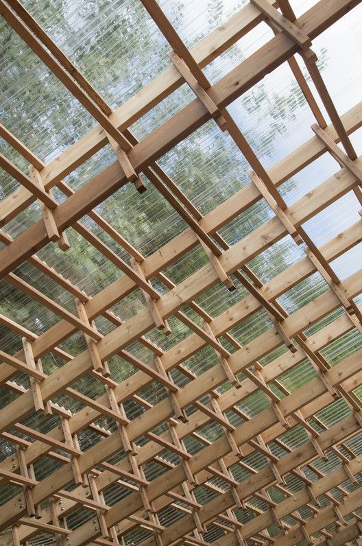 the inside of a wooden structure with lots of wood slats hanging from it's ceiling