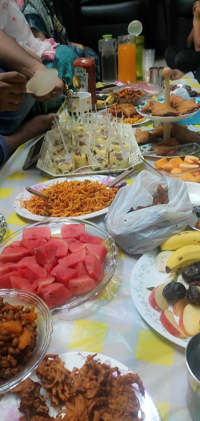 a table filled with plates and bowls full of different types of food, including watermelon