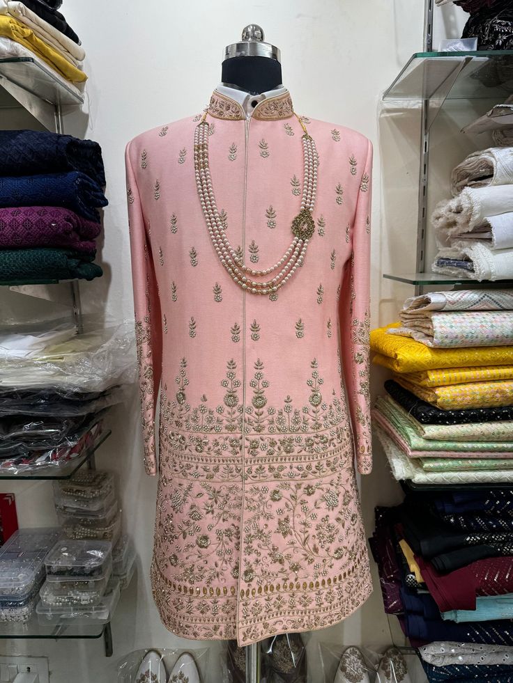 "Make an edgy statement with our ROYAL pink sherwani designed thoughtfully for the modern Indian man. A fusion staple fit for every occasion, adds the right amount of cultural twist to the western silhouette. Color: Black Neck: Mandarin Collar Fabric: Saphire Fabric Embroidery: Kashmiri Embroidery Garment Type: Shrug Indo Western The Product Price is inclusive of: 1 Upper Indo-Western, 1 Sleeve-less Inner Indo-Western and 1 Trouser Style Bottom Model is 6'2\" wearing Size 38 Product color may slightly vary due to photographic lighting sources or your screen settings." Elegant Pink Sherwani With Intricate Embroidery, Festive Pink Embroidered Sherwani, Designer Fitted Pink Sherwani, Pink Fitted Sherwani With Cutdana, Pink Semi-stitched Sherwani With Intricate Embroidery, Indian Jackets, Empire Outfit, Sherwani For Men Wedding, Sherwani For Men