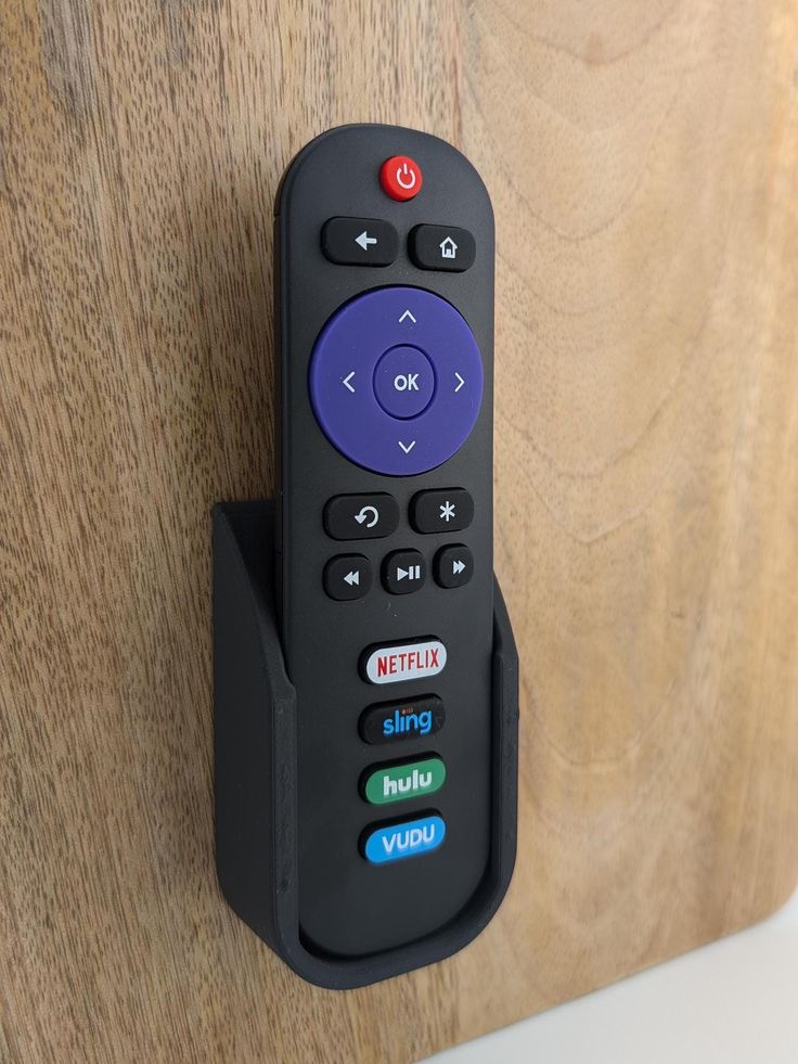 a remote control mounted on the side of a wooden wall