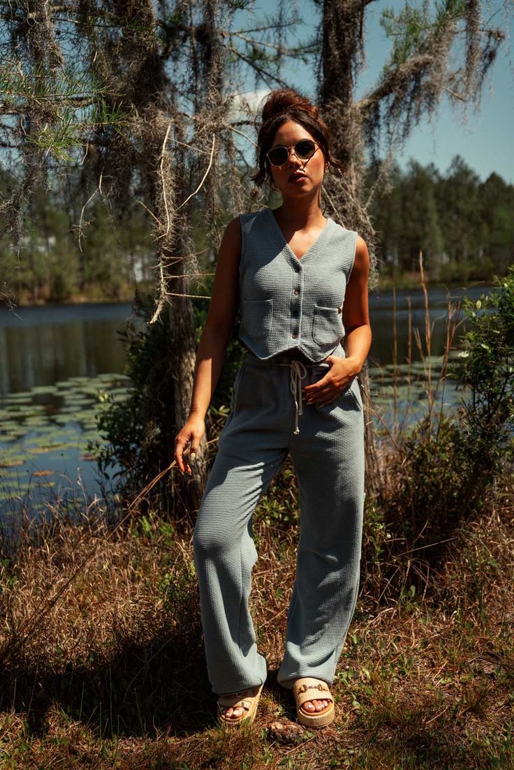 This perfect Summer top can be worn buttoned up on its own or open as a true vest! Our super soft waffle fabric is lightweight and breathable and the perfect Summer companion! Our vest includes 2 small pockets and buttons down center front. 50% Polyester | 50% Cotton Made in Los Angeles, CA SIZE GUIDE Sarah is 5'10 and wearing a size S vest. (Shown in Oak and Slate Blue) Natalie is 5'5 and wearing a size S vest. (Shown in Slate Blue) Brittney is 5'7 and wearing a size M vest. (Shown in Oak and S Versatile Pants, Waffle Fabric, Cargo Pant, Slate Blue, Drawstring Pants, Summer Top, Perfect Summer, Cargo Pants, Size Guide