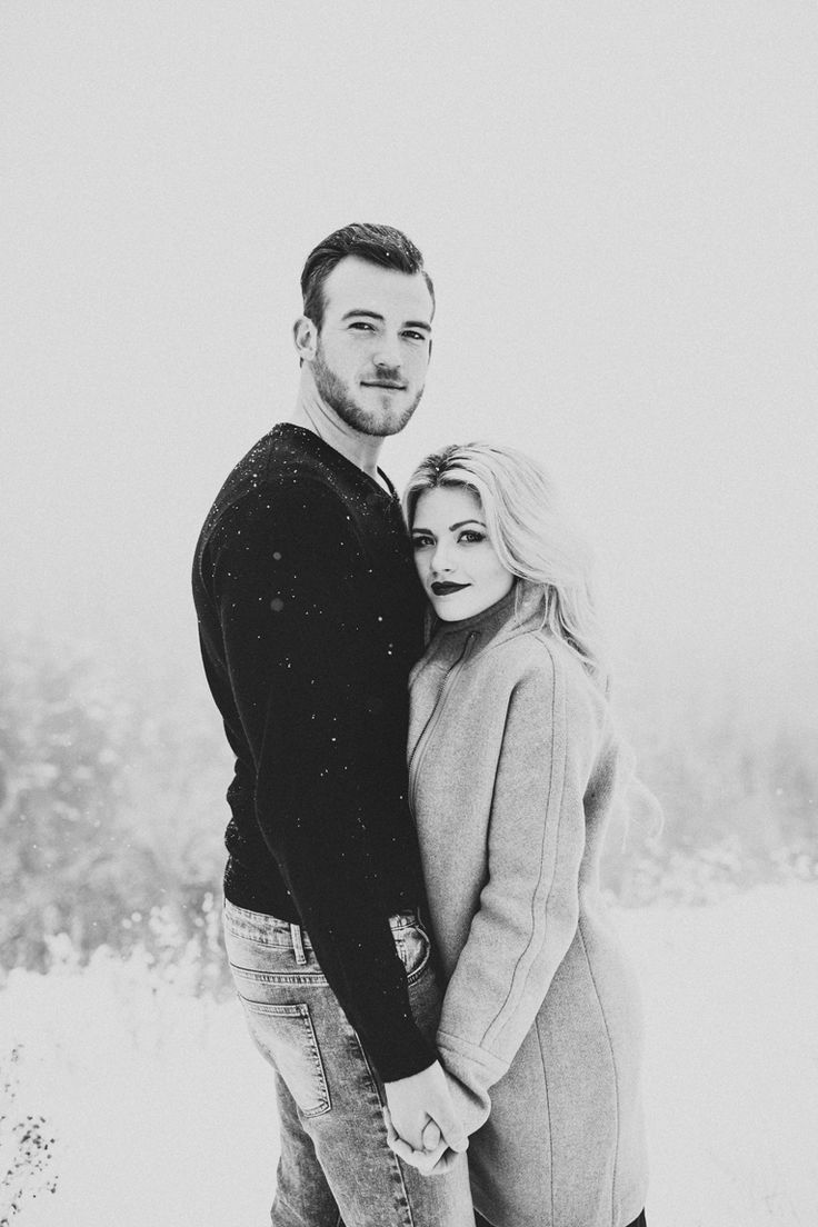 a man and woman are standing in the snow