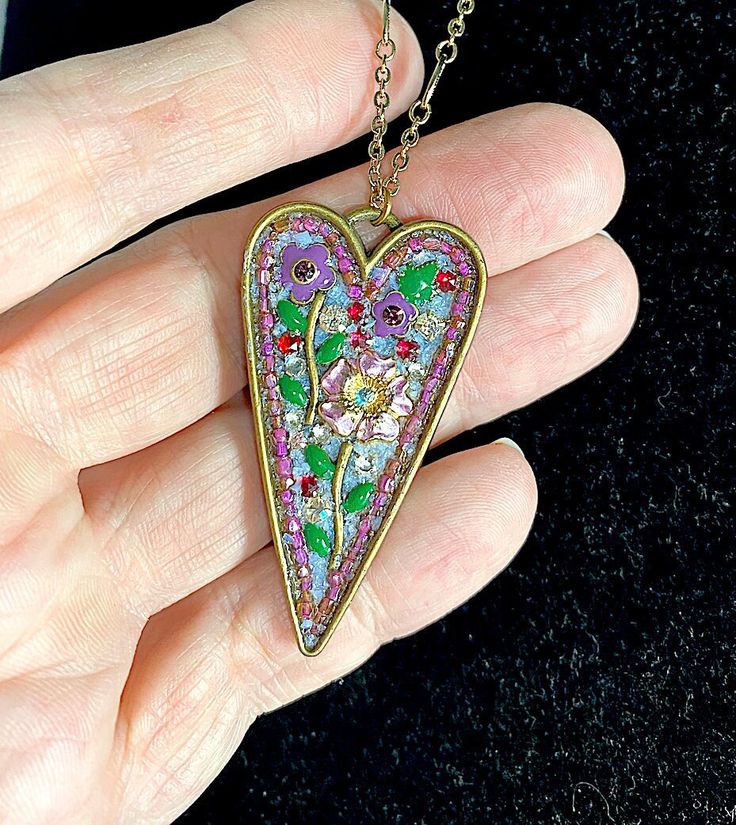 "This pendant is replete with a variety of enameled pink and purple flowers and vintage rhinestones. The heart was then \"grouted\" with fine powdered glass as with a mosaic. The heart frame has been hand lacquered front and back for durability. The pendant itself measures 2\" tall x 1\" wide. The 14K gold chain measures 19\" I will happily adapt this for you. One of a kind-made in my studio. Most of my pieces  are one of a kind as the vintage pieces that I use are hard to come by. I use a combination of vintage  that I find and pieces that I make. My handmade pieces do not have a perfect machine made look. It is a quality which I love. Each piece will be carefully boxed and will be around for generations to come." Vintage Enamel Heart Necklaces, Vintage Heart Enamel Necklaces, Vintage Enamel Heart Necklace, Vintage Heart Enamel Necklace, Heart-shaped Jeweled Jewelry Gift, Heart-shaped Jeweled Jewelry For Gift, Multicolor Enamel Heart-shaped Jewelry, Heart Shaped Jeweled Jewelry For Gift, Multicolor Heart-shaped Enamel Jewelry