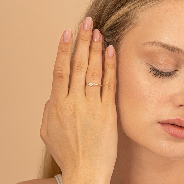 a woman holding her hand up to her ear