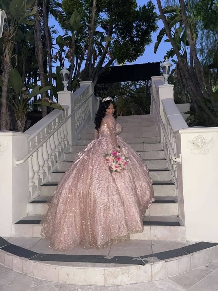 a woman in a pink dress standing on stairs