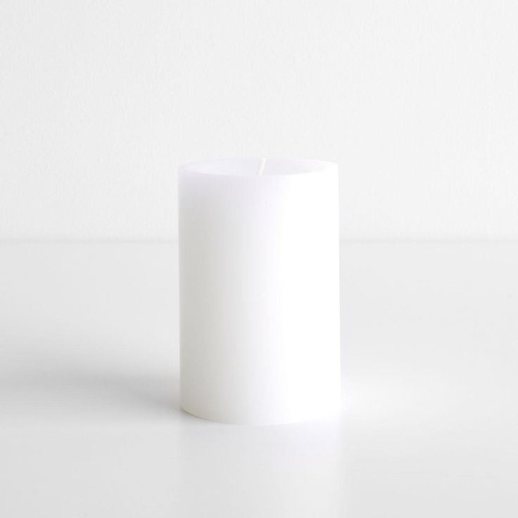 a white candle sitting on top of a table