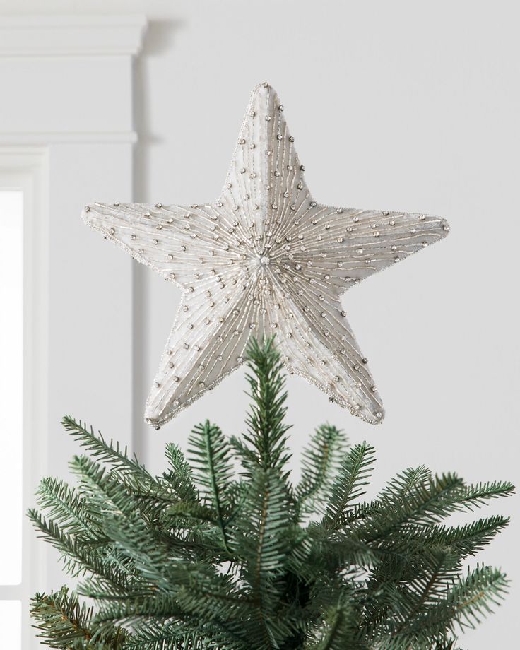 a christmas tree with a star decoration hanging from it