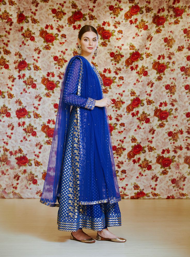 Editor's Note This set features a royal blue embroidered long kurta with dupatta and trouser. Color: Royal Blue Fabric: Silk Chnderi Brocade And Georgette Embroidery Details: Zardozi Care: Dry Clean Only Customize Your Outfit Can't find the size you're looking for? No stress. Just select the size "Custom" while adding the item to your cart. We will follow up with you for your body measurements. To request a color or design customizations, please contact our customer care by using our "Ask us a q Traditional Blue Palazzo Set For Festive Occasions, Traditional Blue Palazzo Set For Festive Season, Traditional Drape Blue Embroidered Palazzo Set, Bollywood Blue Palazzo Set With Resham Embroidery, Blue Bollywood Palazzo Set With Dupatta, Blue Sharara With Straight Kurta For Festive Occasions, Festive Blue Sharara With Straight Kurta, Blue Palazzo Set With Resham Embroidery For Festive Occasions, Blue Palazzo Set With Dabka Work In Chanderi