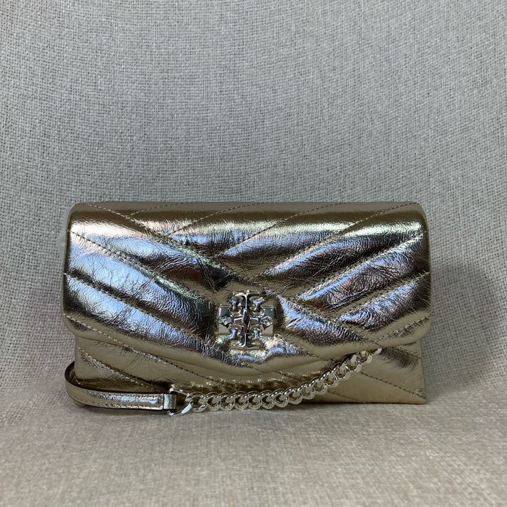 Kira Chevron Chain Wallet By Tory Burch. This Bag Is Made Of Metallic Finish Distressed Leather. Dimensions: 8" Wide Across Bottom X 5" Tall Center X 1.5" Deep. Strap Length 48". Not Adjustable. Interior: 2 Compartments. 1 Zipper Compartment In The Center, 6 Credit Card Slots, 1 Bills Compartment 1 Patch Pocket On The Back Flap Closure Secured With Turn Lock. Fabric Lining. Silver Tone Metalware. Did Not Come With A Dust Bag But Will Provide One That I Bought From Another Ebayer. Designer Silver Bag With Metal Logo, Formal Crossbody Shoulder Bag With Silver-tone Logo Plaque, Silver Shoulder Bag With Silver-tone Logo For Formal Occasions, Silver Shoulder Bag With Silver-tone Logo For Formal Events, Formal Silver Shoulder Bag With Silver-tone Logo, Formal Silver Shoulder Bag With Logo Plaque, Luxury Formal Shoulder Bag With Silver-tone Logo Plaque, Luxury Silver Shoulder Bag With Metal Logo, Silver Evening Bag With Metal Logo