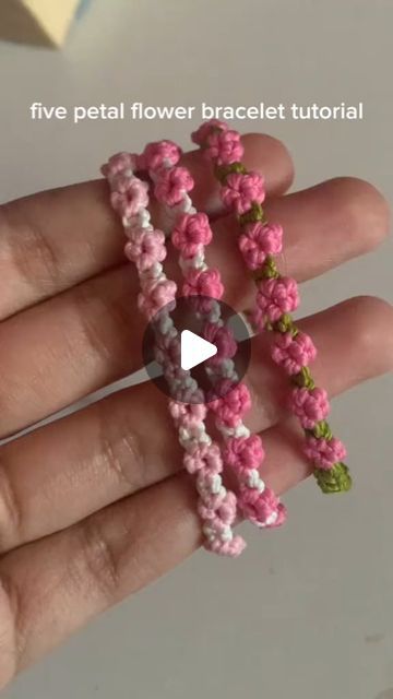 a hand holding three flower bracelets in pink, green and white colors with the text five petal flower bracelet tutor