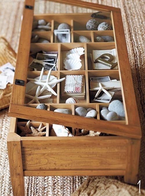 two wooden boxes filled with sea shells and seashells