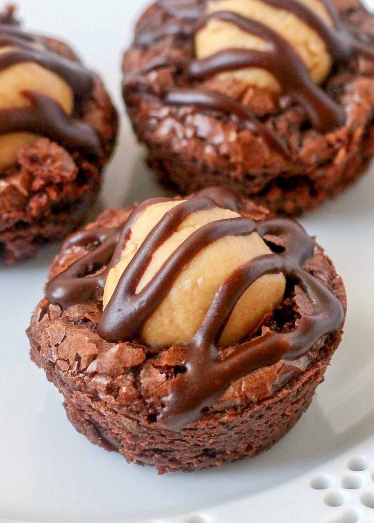 three chocolate cookies with peanut butter on top