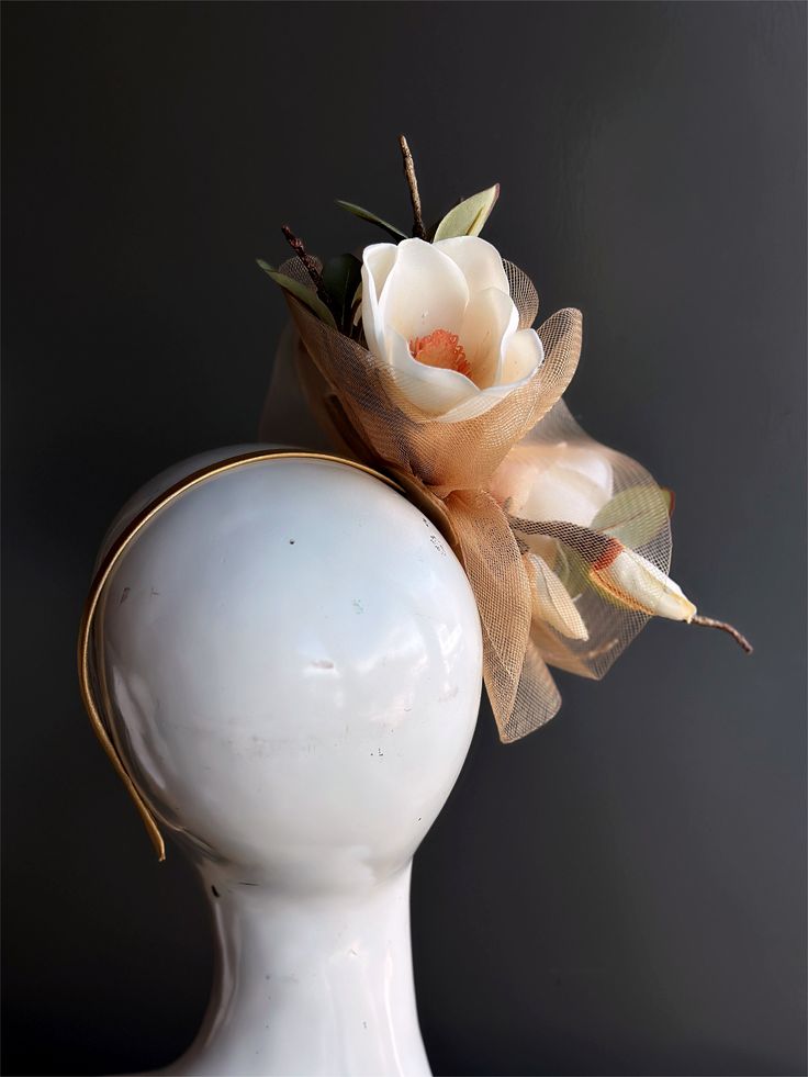 Simply stunning fascinator that encapsulates the beauty of a freshly bloomed magnolia flower. Crafted with intricate precision, the lifelike petals and delicate details are a testament to its elegance. Its natural charm and beauty will have you looking like a true Southern belle, perfect for tea parties and Kentucky derby. Age Group/Gender - Adult/Women Size/Type - One size fits all adults Elegant Flower-shaped Hair Accessories With Handmade Flowers, Elegant Flower Hair Accessories With Handmade Flowers, White Headpieces As A Spring Gift, White Headpieces For Spring Gift, Elegant Handmade Flower Hair Accessories, Flower Headpieces For Kentucky Derby, Handmade Flower Headpieces For Garden Party, Cream Flower Hair Accessories With Handmade Flowers, Kentucky Derby Handmade Flower Hair Accessories